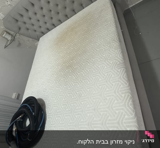 מזרן עם כתם וכלי ניקוי על המיטה